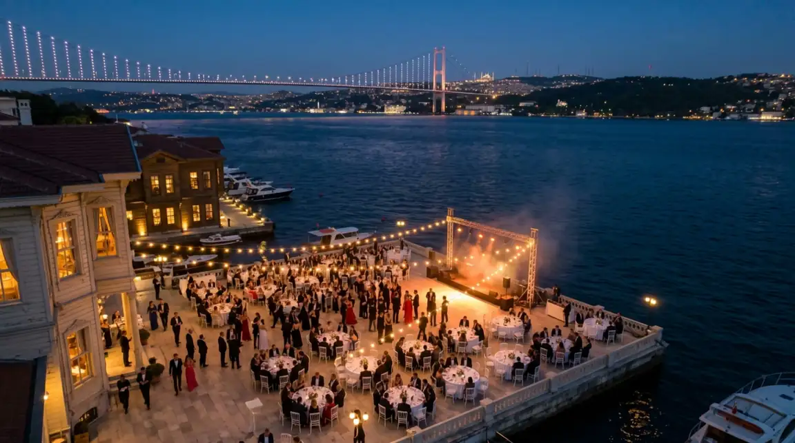 Boğaz kıyısında açık havada bir etkinlik, arkada ışıklı köprü